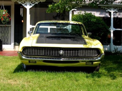 1970 Ford Ranchero - Front view of a yellow 1970 Ford Ranchero with a black hood stripe, parked on a lawn.