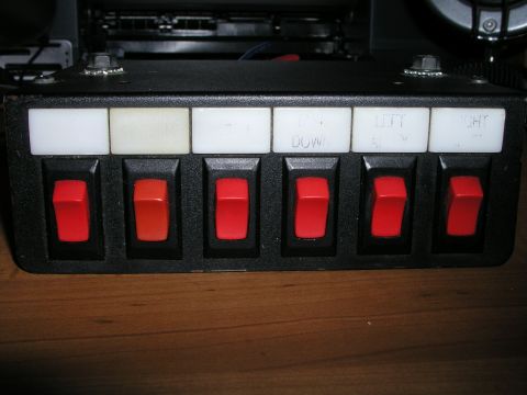 1999 Ford Crown Victoria - This is a close-up of a switch panel with multiple red rocker switches and labels.