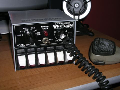 1999 Ford Crown Victoria - A Whelen electronic siren control unit, model WS-5, is shown with a microphone and various function switches.