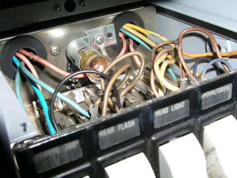 1999 Ford Crown Victoria - Interior view of a vehicle's control panel, showing various wires and switches for functions like rear flash, headlights, and horn/siren.
