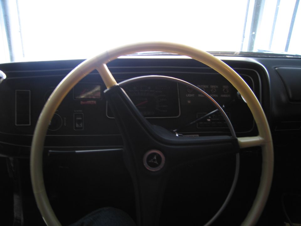 Cream two-spoke steering wheel with Pentastar horn button and instrument panel behind
