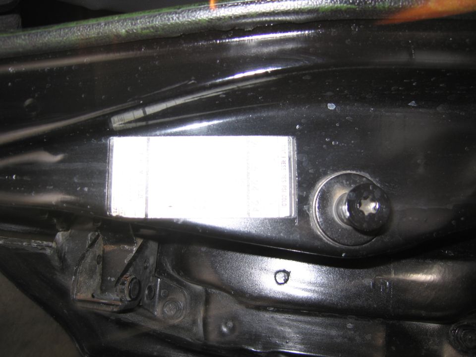 Black door jamb with a white certification label and round body plug