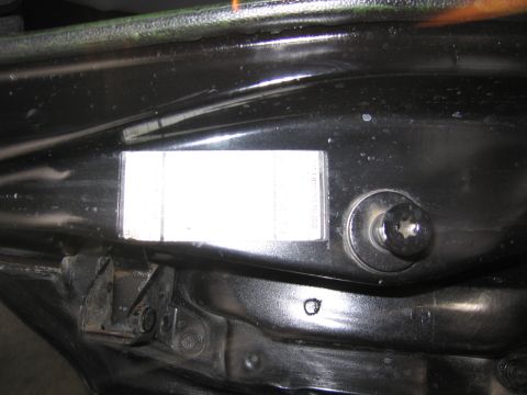 1991 Ford LTD Crown Victoria - glossy black inner fender panel in an engine bay with a domed bolt head and a white paper specification sticker affixed to it.