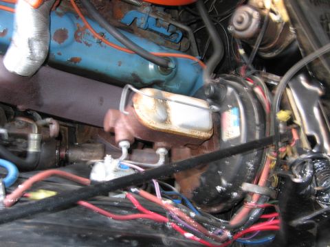 1991 Ford LTD Crown Victoria - blue painted V8 engine with raised lettering on the valve cover, a rusty brake booster and a colorful tangle of wiring below.