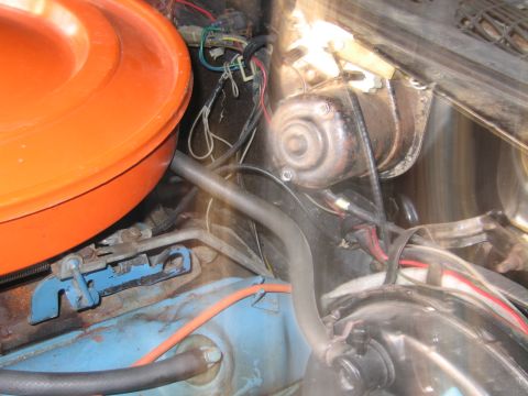 1991 Ford LTD Crown Victoria - engine bay view with an orange round air cleaner at left, a cylindrical brake booster, a blue engine block and orange ignition wires.