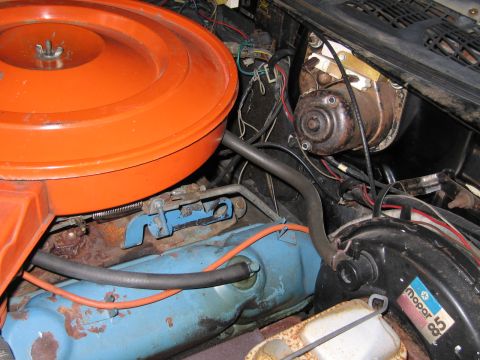 1991 Ford LTD Crown Victoria - engine bay showing an orange air cleaner, a blue engine block, raised valve-cover lettering and a brake booster bearing a Mopar logo.