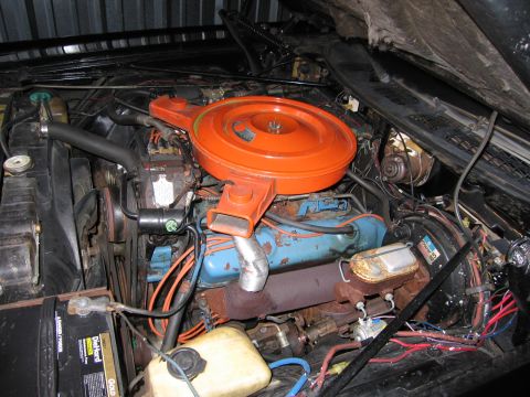 1991 Ford LTD Crown Victoria - full engine bay overview showing an orange air cleaner atop a blue V8 block, surrounded by hoses, wiring, a reservoir and a battery.
