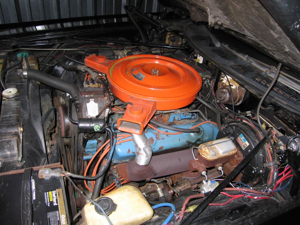 Full engine bay overview with orange air cleaner on a blue V8 and DieHard battery