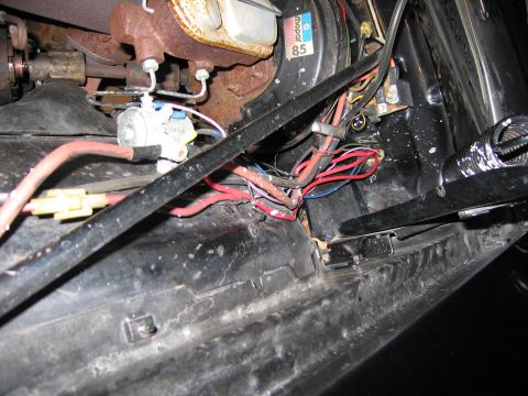 1991 Ford LTD Crown Victoria - edge of an engine bay showing bundled red and blue wiring, an inline connector and a brake booster bearing a Mopar label.