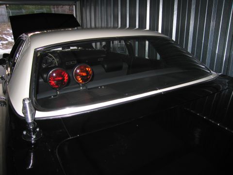 1991 Ford LTD Crown Victoria - two-tone car in a storage unit with red and amber rotating beacon lights mounted on the rear parcel shelf and a chrome siren on the fender.