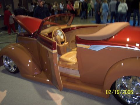 1979 Ford Bronco - Custom hot rod convertible with a unique wood-grain interior and red hood is displayed indoors.