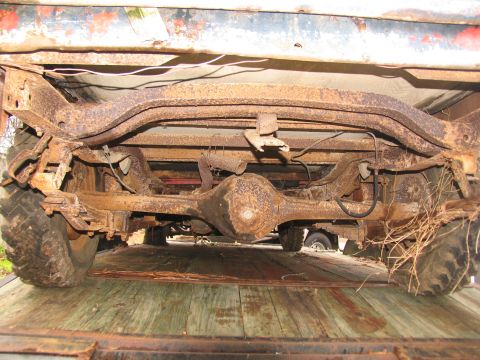 1949 Chevrolet C/K Pickup - Underside view of a heavily rusted 1949 Chevrolet C/K Pickup's rear axle and suspension system.