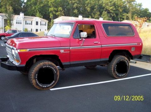 1979 Ford Bronco - A red Ford Bronco is parked in a lot with buildings and trees in the background. The date 09/12/2005 is visible.