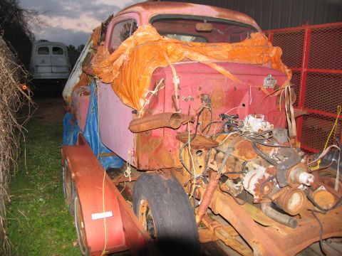 1952 Ford Pickup - Rusted 1952 Ford Pickup truck chassis on a trailer, with engine components visible. A second vehicle is in the background.