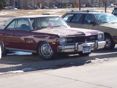 1972 Ford Ranchero - Maroon 1974 Dodge Dart with a white vinyl roof parked next to a tan SUV.