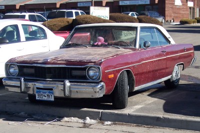 1972 Ford Ranchero - This maroon Dodge Dart, likely from the mid-1970s, shows signs of wear, particularly on its hood.