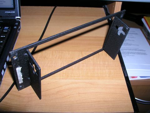1999 Ford Crown Victoria - A black metal bracket is shown on a desk, with a laptop and papers in the background.