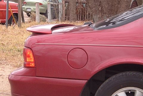1994 Ford Thunderbird - Rear view of a red 1994 Ford Thunderbird, showing its distinctive spoiler and fuel door.