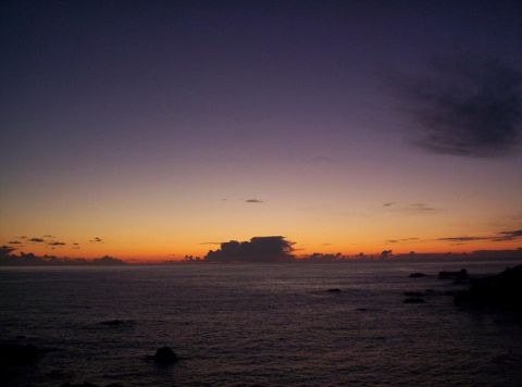 1989 Ford Bronco - The sun sets over the ocean, casting a gradient of purple and orange hues across the sky.