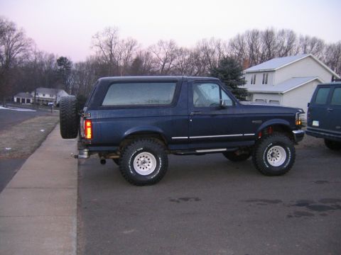 1994 Ford Bronco - This 1994 Ford Bronco is shown from the side, with a spare tire on the rear and another vehicle behind it.