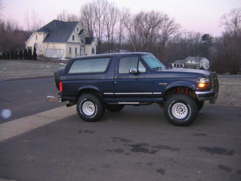 1994 Ford Bronco - This lifted Ford Bronco, likely from the early to mid-1990s, is shown from a three-quarter front angle.