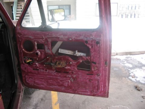 1991 Ford Bronco - Interior of a car door with the panel removed, revealing internal components.