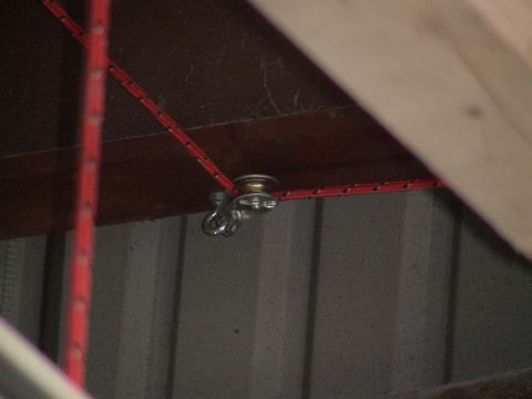 1993 Ford C-350 (Centurion Conversions) - A pulley system with a red rope is mounted to a wooden beam, likely for lifting or lowering.