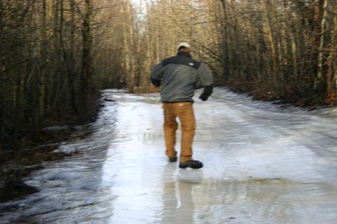 2003 Jeep TJ - A person walks down a slippery, ice-covered forest road on a cold day.