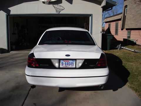 2000 Ford Crown Victoria - White sedan with tinted taillights parked in a driveway.