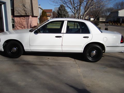 2000 Ford Crown Victoria - This white 2000 Ford Crown Victoria is shown from the side, tinted windows and black steel wheels.