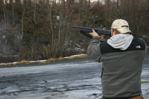 2003 Jeep TJ - Man shooting a shotgun in an outdoor, wintery scene with trees and icy ground.
