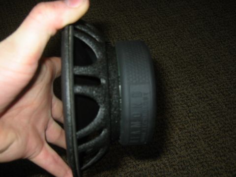 1995 Ford Bronco - A close-up shows a car speaker held by a hand, with some text visible on its side.