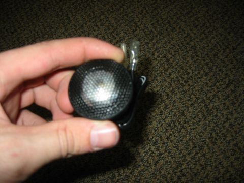 1995 Ford Bronco - Close-up of a car speaker tweeter being held in a hand.