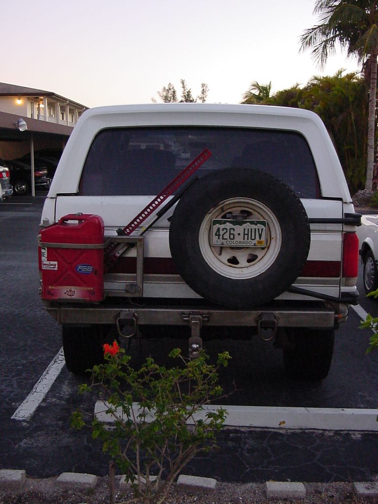 This shows the stainless swing-away gas can/jack carrier and the stock swing away tire carrier.  It also shows the rear stainless bumper with the integral receiver hitch.  This is a stout hitch!
