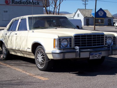 1972 Ford Ranchero - Cream 1977 Ford Granada sedan parked in lot with RadioShack in background.