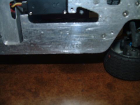 1994 Ford Bronco - The underside of a remote-controlled car chassis reveals stamped lettering, but no clear vehicle identification.