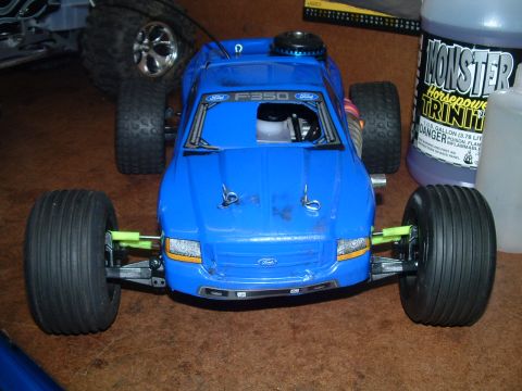 1994 Ford Bronco - A blue remote control truck is shown from the front, with another vehicle's wheel visible to the left.