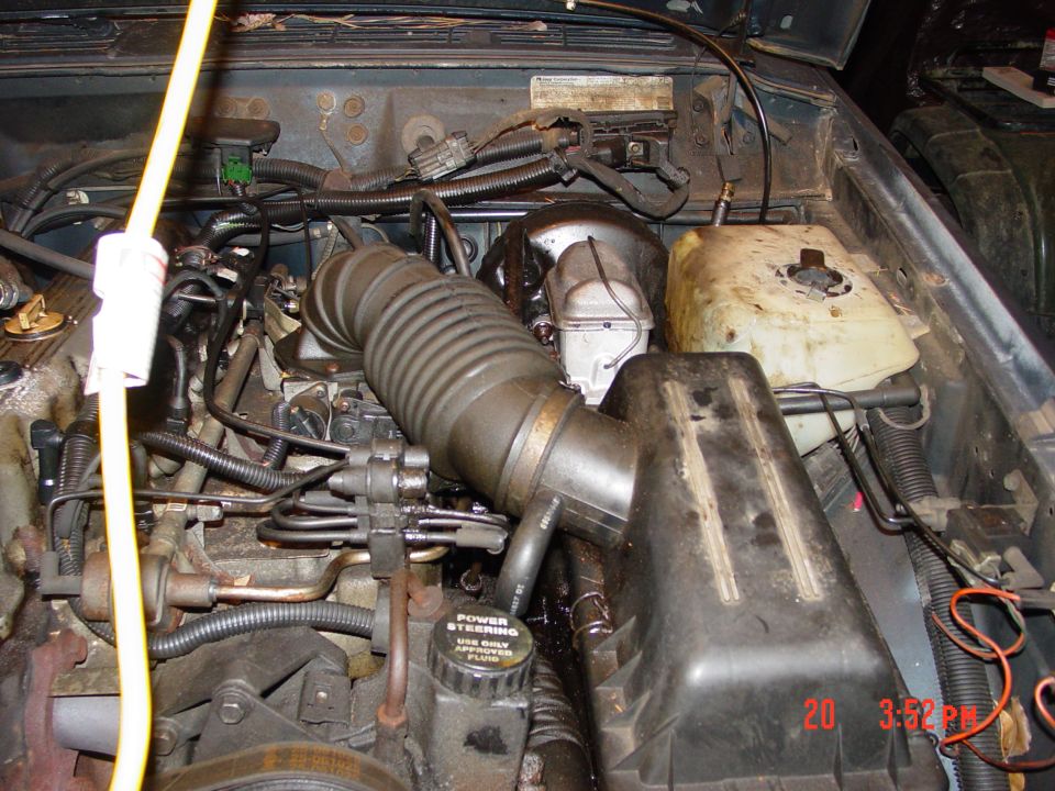 Engine bay with air intake tube and power steering reservoir