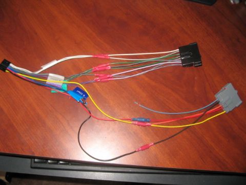 1991 Ford Bronco - A wiring harness with multiple colored wires and connectors lies on a wooden surface.