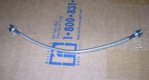 1992 Ford Probe - A braided metal hose with silver fittings is shown against a cardboard background with company information.