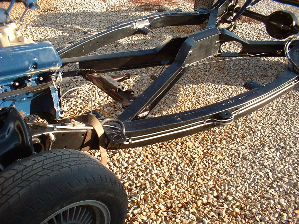 Vehicle frame with blue engine block and tire visible
