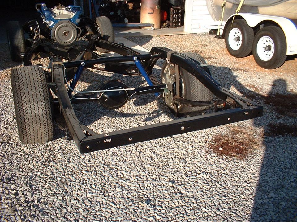 Vehicle chassis with engine and tires on gravel