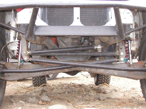 1984 Ford Bronco - Close-up view of the front suspension and radiator of a modified off-road vehicle.