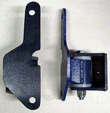 1984 Ford Bronco - Close-up view of two vehicle door hinges, one a roller mechanism.