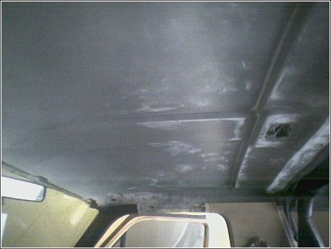 1981 Ford Bronco - The headliner of a vehicle shows wear and tear, with visible structural supports.
