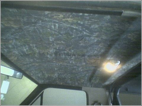 1981 Ford Bronco - Vehicle interior ceiling shows camouflage headliner and a lit dome light.