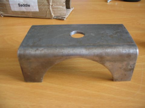 1981 Ford Bronco - A metal part, possibly a suspension component, sits on a wooden surface next to a cardboard box.