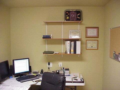 1985 Ford Bronco - An office scene a desk, computer equipment, and storage shelves on a pale yellow wall.