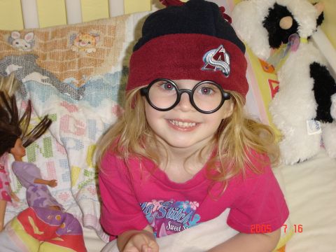 1993 Ford Bronco - A young child wearing a hat and round glasses smiles while surrounded by toys and stuffed animals.