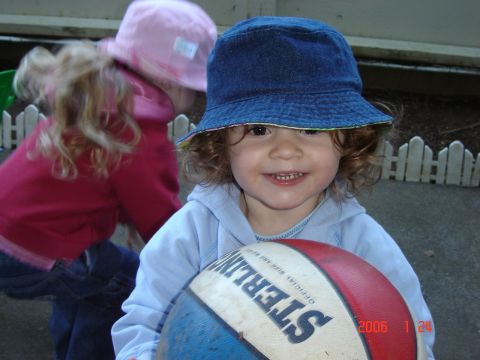1993 Ford Bronco - Two young children are playing outdoors with a basketball, one in a blue bucket hat and the other in a pink hat.